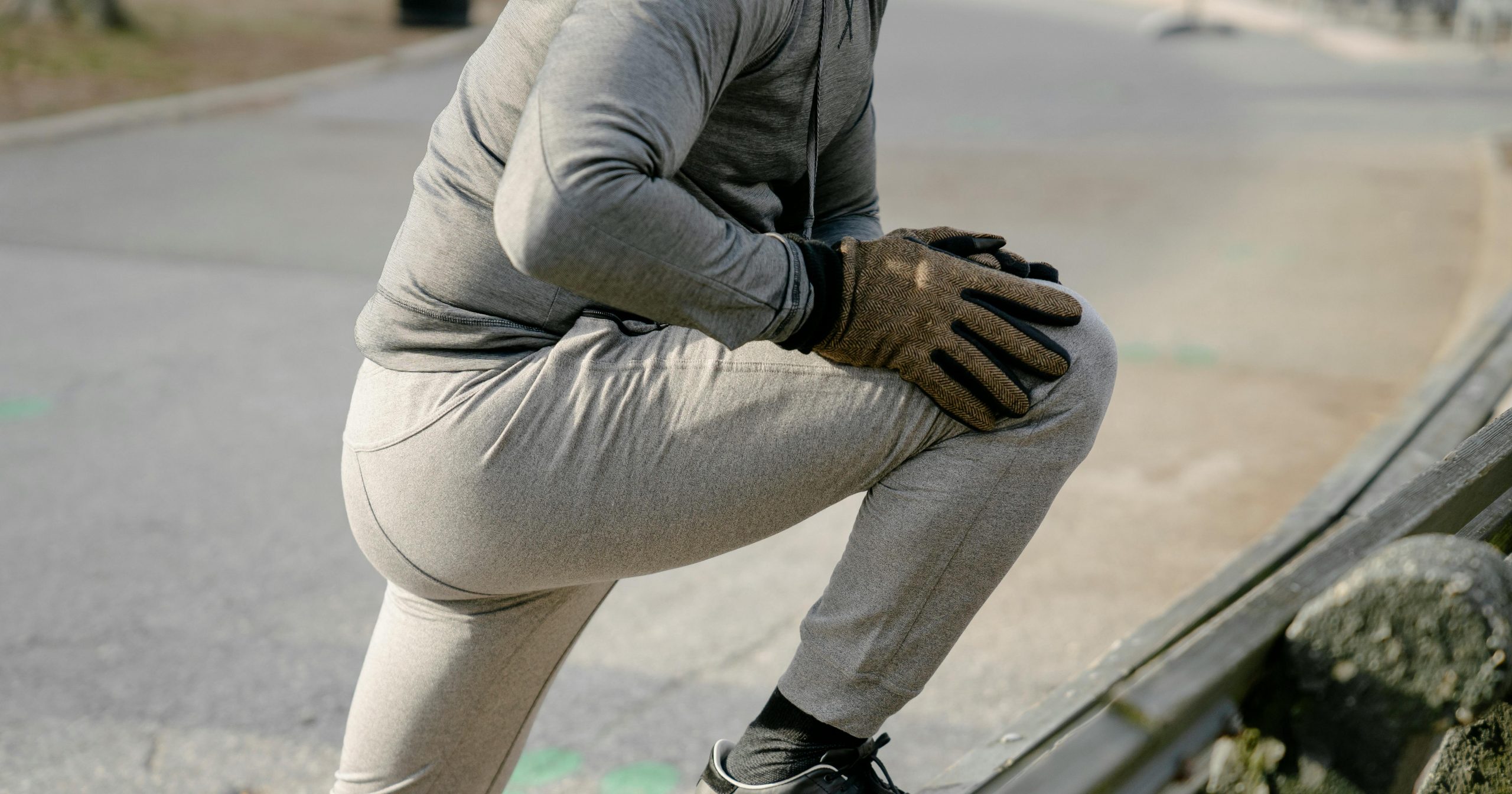 man stretching his legs in a park